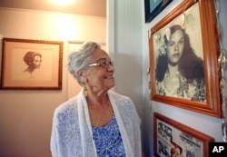 Emma Veary, 86, looks at a photograph of herself, taken when she was a teenager, in Makawao, Hawaii.