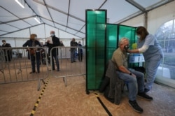 A person receives the Oxford/AstraZeneca coronavirus vaccine at an NHS vaccination center in York, England, Jan. 22, 2021.