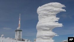 Wind and white frost have formed an ice sculpture on Brocken mountain in the Harz region, Germany, Sunday, March 18, 2018. 