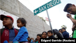 Integrantes de una caravana de inmigrantes provenientes de Centroamérica forman fila para recibir un desayuno tras viajar a través de México, antes de solicitar asilo en Estados Unidos, en un refugio en Tijuana, México. Foto de Archivo.