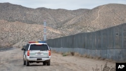 A U.S. Border Patrol agent drives near the U.S.-Mexico border fence in Sunland Park, New Mexico, Jan. 4, 2016. 