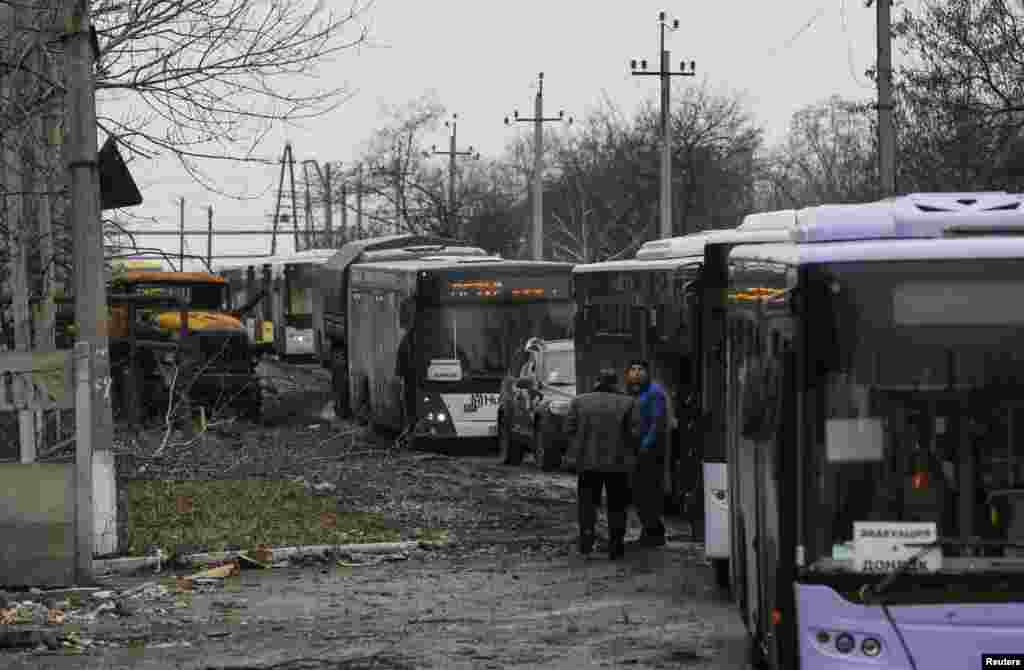 Buses wait along a road while traveling in the direction of the village of Debaltseve, Feb. 6, 2015.