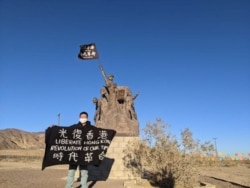 Alex Lee holds a flag after traveling on foot from West Covina to Barstow, California, in this undated photo. (Photo courtesy of Alex Lee)
