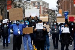 Health care workers take part in a national day of action calling on federal and local authorities to provide more Personal Protective Equipment (PPE) and other support during the coronavirus pandemic, in New York City, New York, April 9, 2020.