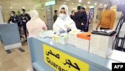 Des agents de la santé se préparent à prendre la température corporelle des voyageurs qui arrivent à l'aéroport international du Caire le 1er février 2020, (AFP)