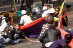 Protesters lie on the ground after police opened fire to disperse an anti-coup protest in Mandalay, Myanmar, March 3, 2021. Among them, Angel, 19, bottom-left, also known as Kyal Sin, took cover before she was shot in the head.