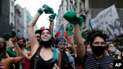 Abortion-rights activists celebrate as Argentine lower house approves a bill that would legalize abortion outside Congress in Buenos Aires, Argentina, Dec. 11, 2020. The bill now moves to the Senate.