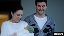 FILE - New Zealand Prime Minister Jacinda Ardern carries her newborn baby Neve Te Aroha Ardern Gayford with partner Clarke Gayford out of the Auckland Hospital in New Zealand, June 24, 2018.