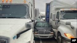 In a photo released by the Kansas Highway Patrol, a car is wedged between two trucks during icy weather Jan. 4, 2024, in Salina, Kansas.