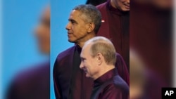 El presidente ruso Vladimir Putin pasa frente al presidente Obama antes de tomarse la foto de familia de la APEC.