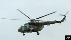FILE - In this in this Sept. 18, 2002 file photo a Mi-8 helicopter flies over the Chechen regional capital Grozny, Russia. A helicopter similar to the one pictured has been shot down in Syria and Russian President Vladimir Putin's spokesman says all people aboard it have been killed, Aug. 1, 2016.