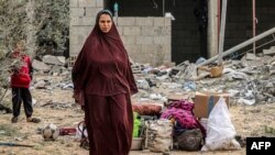 A woman stands by items that were salvaged from a building that was hit overnight during Israeli bombardment in Rafah in the southern Gaza Strip on March 26, 2024 amid the ongoing conflict in the Palestinian territory between Israel and the militant group