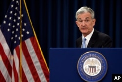 Federal Reserve Chair Jerome Powell gathers his notes as he concludes his news conference in Washington, March 20, 2019.