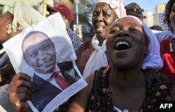 FILE - Supporters of Kenya's President Uhuru Kenyatta celebrate in the streets of Nairobi following the International Criminal Court's ruling to drop crimes-against-humanity charges against him, at the ICC courts at the Hague, Dec. 5, 2014.