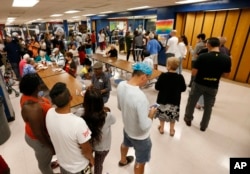 People at a Red Cross shelter set up at North Miami Beach Senior High School wait in line for lunch in North Miami Beach, Florida, Sept. 8, 2017.
