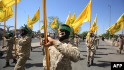 FILE - Iraqi Shiite fighters from the Nujaba armed group march during a military parade marking Al-Quds (Jerusalem) International Day in Baghdad, May 31, 2019.