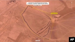 In this photo made from video taken from Russian Defense Ministry official web site on Dec. 2, 2015, an aerial image of what they purport shows lines of oil trucks 14 km (8.8 miles) east of Dayr-az-Zawr, Syria.
