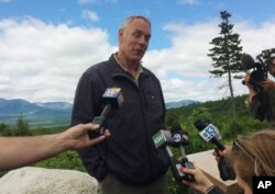 FILE - Interior Secretary Ryan Zinke talks with reporters with part of Mount Katahdin in the background at the Katahdin Woods and Waters National Monument near Staceyville, Maine, June 14, 2017.
