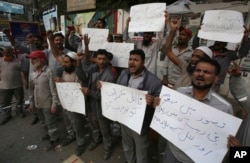 Pakistani civil society activists protest against the rape and killing of a young girl, in Karachi, Pakistan, Jan. 10, 2018. Placard at bottom center reads" remove the incompetent rulers."