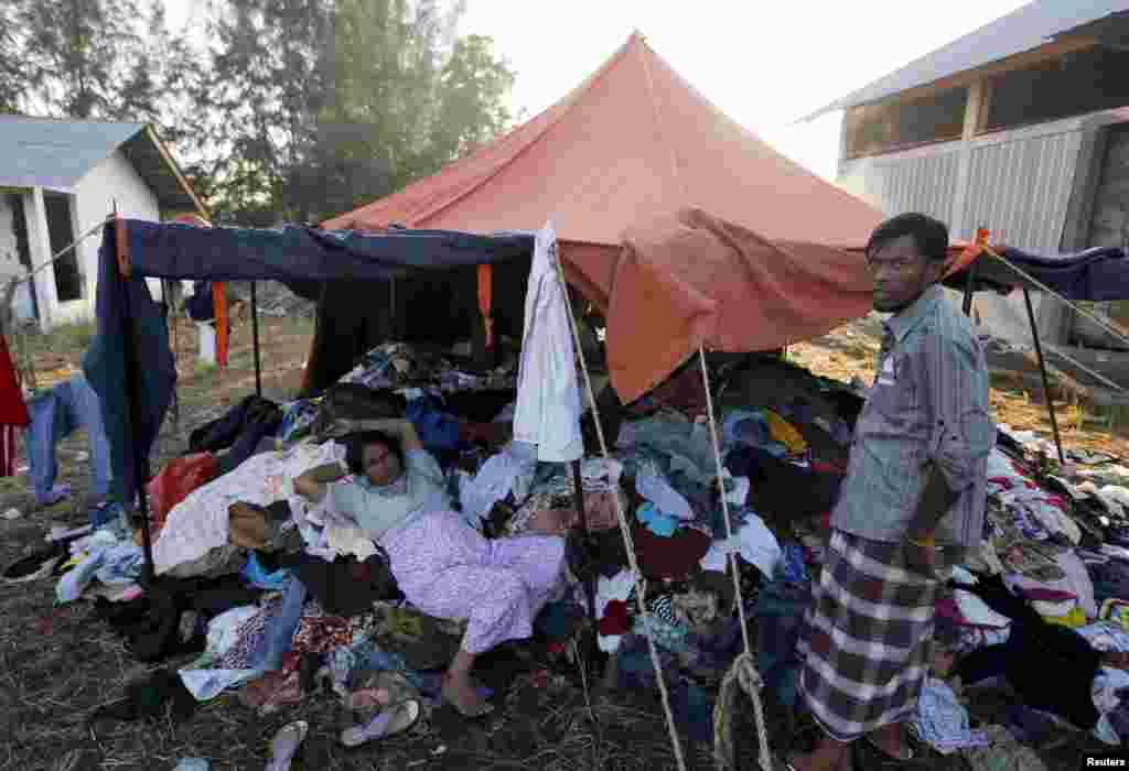 A Rohingya migrant woman who recently arrived in Indonesia by boat lies on a pile of donated clothes at a shelter in Kuala Langsa, Aceh Province, Indonesia, May 19, 2015.