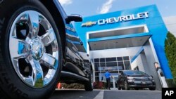 FILE - The logo on the wheel of an SUVappears in front of a Chevrolet dealership in Richmond, Va., April 26, 2017. 