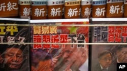 FILE - In this July 4, 2019, photo, magazines having a cover featuring images of Chinese President Xi Jinping and then-U.S. President Donald Trump and containing a story on U.S.-China trade, are on sale at a roadside book stand in Hong Kong.