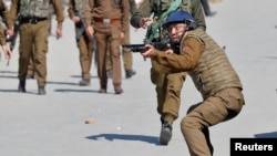 Indijski policajac usmjerava oružje na prema demonstrantima tokom protetsta nakon molitve u petak u Srinagaru, 5. ožujka 2021.