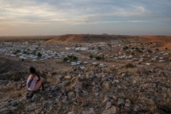 A Tigray girl sits atop a hill overlooking the Um Rakouba refugee camp, hosting people who fled the conflict in the Tigray region of Ethiopia, in Qadarif, eastern Sudan, Dec. 14, 2020.