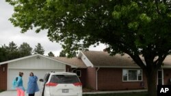 Dr. Beth Oller and nurse Heather Mackey put on protective gear as they prepare to make a house call to examine and immunize 8-week-old Margaret Berkley, May 21, 2020, in Stockton, Kan. 