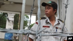 FILE - A security officer stands guard at an industrial park in southern Vietnam's Binh Duong province, where mobs had attacked foreign-owned factories following anti-China protests across the country, May 17, 2014.