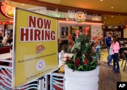 FILE - A restaurant posts a sign indicating they are hiring, in Miami, Florida, Feb. 9, 2016.