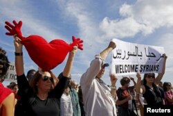 Protesters gather during a demonstration to welcome refugees at Praca Comercio in Lisbon, Portugal, Sept. 12, 2015.