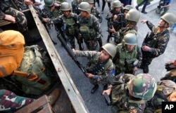 One of the military's first battalions to be deployed in the city of Marawi board a military truck as they arrive to a hero's welcome at Villamor Air Base, Oct. 20, 2017, in Pasay city, southeast of Manila, Philippines.