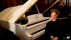 FILE - Billy Joel poses at a piano in New York, Dec. 12, 2011.