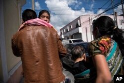 Seven-year-old Mayra Cristina Gregorio Velasquez is carried by her father after they were reunited at the shelter "Nuestras Raices," following her detention by U.S. immigration authorities in Guatemala City, Tuesday, Aug. 7, 2018.