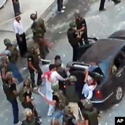 An grab taken on June 27, 2011 from footage uploaded on YouTube on June 24 allegedly shows Syrian security forces beating two men with batons and shoving them in the trunk of a car in Barza on the outskirts of Damascus (editorial content, date and locatio