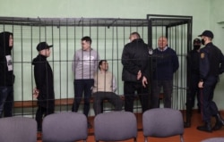 Syarhei Tsikhanouski speaks with co-defendants including Dmitry Popov, Artyom Sakov, Vladimir Tsyganovich and Igor Losik during a court hearing in Gomel (Homel), Belarus, Dec. 14, 2021.