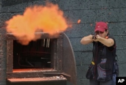 FILE - Olympic skeet shooter Kim Rhode hits a clay pigeon as she practices at Oak Tree Gun Club, in Newhall, California, June 8, 2011.
