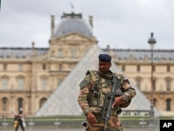 FILE - A soldier patrols in the courtyard of the Louvre Museum in Paris, Nov. 17, 2015.
