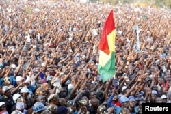 Supporters of Uganda's leading opposition presidential candidate Kizza Besigye of the Forum for Democratic Change (FDC) party hold their flag during a campaign in Jinja industrial town, in eastern Uganda, Feb. 12, 2016.