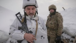 Ukrainian servicemen stand in a trench on the front line in the Luhansk area, eastern Ukraine, Jan. 27, 2022.