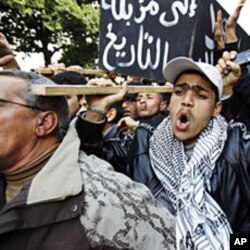 Protesters carry a fake coffin with Arabic sign reading, "to history's dustbin," to symbolize the death of he RCD party of ousted president Zine al-Abidine Ben Ali, Tunis, 19 Jan 2011