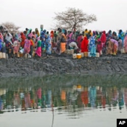 Displaced women gather to collect water from a water hole near Jamam refugee camp in South Sudan's Upper Nile State, March 10, 2012.