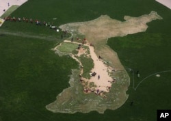 Workers plant flowers in the shape of the Korean Peninsula on the lawn to wish for a successful inter-Korean summit at Seoul Plaza in Seoul, South Korea, April 13, 2018. North Korean leader Kim Jong Un will meet South Korean President Moon Jae-in April 27 at the border.