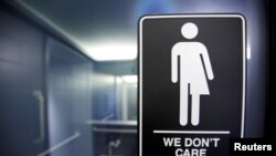 Sebuah poster ditempel di luar toilet Hotel 21C Museum di Durham memprotes larangan bagi transgender untuk menggunakan toilet umum di Durham, North Carolina, 3 Mei 2016. (Foto: Jonathan Drake/Reuters)