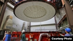 Workers at Steward Observatory Mirror Lab prepare the rotating furnance in which the GMT mirror was cast. (Steward Observatory Mirror Lab/University of Arizona)
