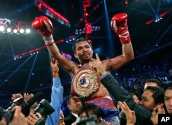 Manny Pacquiao from the Philippines wears the champion's belt after defeating Brandon Rios of the United States in the WBO international welterweight title fight, Nov. 24, 2013, in Macau.
