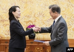 North Korean leader Kim Jong Un's sister Kim Yo Jong hands an autographed letter from Kim Jong Un to South Korea's President Moon Jae-in during their meeting at the presidential Blue House in Seoul, Feb. 10, 2018.