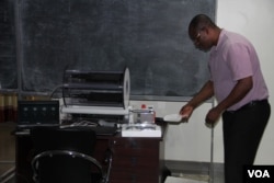 Physicist Ketevi Assamagan demonstrates how a cloud chamber works. (A. Phillips/VOA)