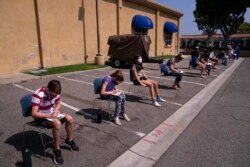 FILE - Children ages 12 to 15 wait to get their vitals checked before getting their Pfizer COVID-19 vaccine at Families Together of Orange County in Tustin, Calif., May 13, 2021.